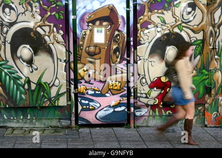 STOCK. Pourriture urbaine. Une femme passe devant un bâtiment peint sur Stokes Croft à Bristol. Banque D'Images