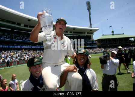 Shane Warne en Australie est porté sur le terrain avec le trophée officiel de Ashes par Michael Clarke et Andrew Symonds (à droite) après avoir battu l'Angleterre le quatrième jour du cinquième match de Test à la SCG à Sydney, en Australie. Banque D'Images