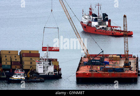 Un conteneur est soulevé du cargo mis à la terre MSC Napoli et placé sur une barge de grue alors que le navire se trouve à un kilomètre de la côte près de Sidmouth, Devon. Banque D'Images