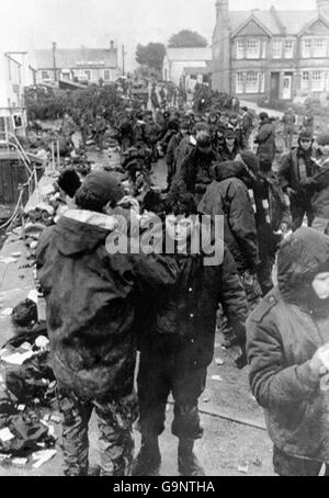 Les prisonniers de guerre argentins faisant l'objet de perquisition dans les rues de Port Stanley avant d'être transférés dans l'aérodrome où ils étaient détenus avant d'être emmenés à des navires d'attente. Banque D'Images