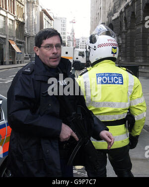 La police armée regarde la rue tandis que la camionnette blindée transportant certains des présumés bombardiers d'engrais apporte les désamorcer pour résumer l'affaire au Old Bailey, à Londres. Banque D'Images