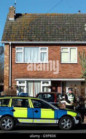 Un policier à l'extérieur d'une maison à Coventry Close, Werrington, Peterborough, où les corps d'une femme et de deux enfants de moins de cinq ans ont été découverts peu après 17 h hier. Banque D'Images