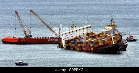 Un navire transportant deux grandes grues se rapproche du navire de cargaison mis à la terre MSC Napoli car il se trouve à un kilomètre et demi de la côte près de Sidmouth, Devon. Banque D'Images