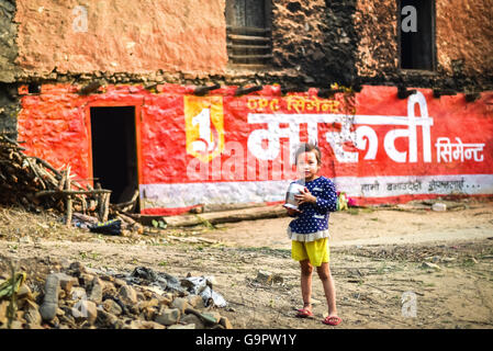 Petite fille tenant un récipient en métal. Dhulikhel, district de Kavrepalanchowk, Népal. Banque D'Images