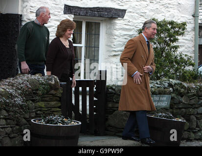 Le Prince de Galles (à droite) à l'extérieur du Yew Tree bed and breakfast à Rosthwaite, dans le Lake District, avec les propriétaires Joe et Hazel Relph, après y avoir passé la nuit pendant une visite au nord-ouest. Banque D'Images