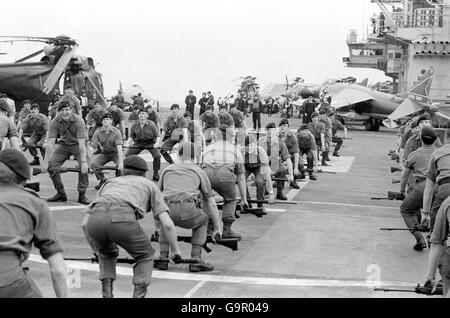 Hommes d'UNE compagnie, 40 Royal Marine Commando travaillant sur le pont du porte-avions HMS Hermes alors qu'elle se dirige vers le sud avec la force navale britannique pour les Malouines à la suite de l'invasion Argentine. Banque D'Images