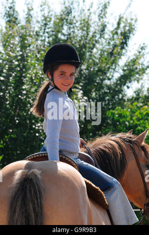 Girl riding Pony / casque, dun Banque D'Images