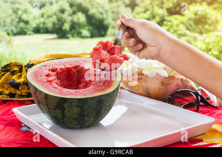 L'accent sur la pastèque pastèque et demi cuillère sur plateau blanc, pelle à main de pastèque, melon d'eau fraîche en été journée ensoleillée Banque D'Images