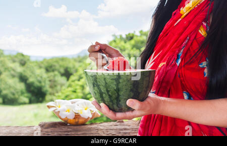 Melon d'eau à l'accent sur les femmes et cuillère hand holding watermelon, les femmes en robe d'été facile de vous détendre manger pastèque à sunny che Banque D'Images