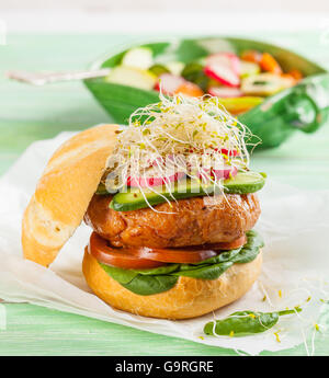 Un délicieux hamburger gastronomique avec des légumes frais : tomate, épinards, choux, radis et cornichons Banque D'Images