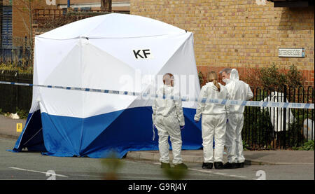 Des officiers sur la scène du crime à la jonction de Hall Road et Buttermere Close, Leytonstone, dans l'est de Londres, où Paul Erhahon, 14 ans, est décédé la nuit dernière après avoir été poignardé lors d'une attaque au couteau de bande qui a également laissé un jeune de 15 ans dans un état critique.Le marqueur jaune est placé près des taches de sang des victimes. Banque D'Images