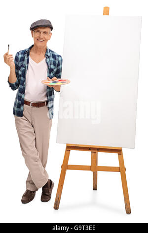 Portrait d'un artiste confirmé debout à côté d'une toile blanche isolé sur fond blanc Banque D'Images