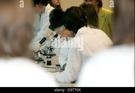 La reine Elizabeth II de Grande-Bretagne regarde dans un microscope les fibres d'une scène de crime simulé lors de sa visite au département de médecine légale de l'East Berkshire College, Windsor. Banque D'Images