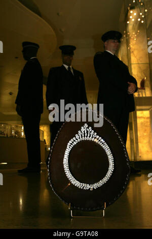 Les gardes de sécurité de Harrods regardent plus d'un demi-œuf de chocolat noir belge de 40 cm qui est fixé avec un collier en forme de poire et de diamants marquise. Banque D'Images