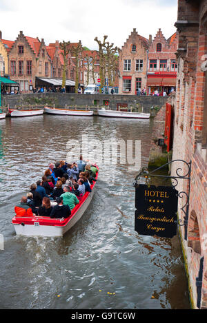 Les touristes profitant d'une excursion en bateau sur les canaux de Bruges en Belgique. Banque D'Images