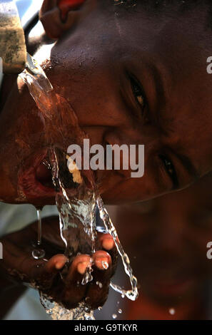 Un jeune garçon boit de l'eau à la pompe de Springbokpan, à 95 km au sud de Zeerust, dans la province du Nord-Ouest, en Afrique du Sud. Il n'y a qu'une pompe pour un village de 3,500. Banque D'Images