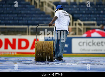 Le personnel au sol essaie de nettoyer le terrain pendant que la pluie arrête de jouer pendant le match de la coupe du monde de cricket 2007 de l'ICC au parc Sabina, à Kingston, en Jamaïque. Banque D'Images