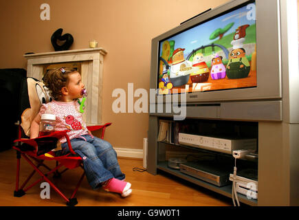 Maisy Byrne, 2 ans, regarde à la télévision les programmes de ses enfants préférés chez elle à Merseyside. Banque D'Images