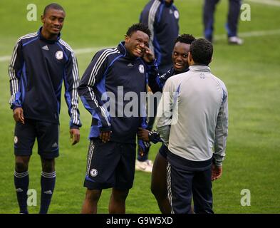 Michael Essien, de Chelsea, fliche avec l'oreille de John Mikel pendant l'entraînement Banque D'Images