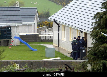 Gardaï sur la scène du village de Monageer, près d'Enniscorthy, à Co Wexford, où quatre membres d'une famille - deux enfants et leurs parents - ont été trouvés morts. Banque D'Images