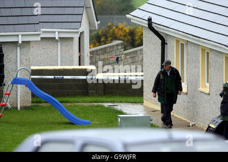 Gardaï sur la scène du village de Monageer, près d'Enniscorthy, à Co Wexford, où quatre membres d'une famille - deux enfants et leurs parents - ont été trouvés morts. Banque D'Images