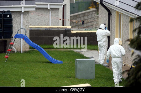 Gardaï sur la scène du village de Monageer, près d'Enniscorthy, à Co Wexford, où quatre membres d'une famille - deux enfants et leurs parents - ont été trouvés morts. Banque D'Images