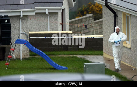 Gardaï sur la scène du village de Monageer, près d'Enniscorthy, à Co Wexford, où quatre membres d'une famille - deux enfants et leurs parents - ont été trouvés morts. Banque D'Images