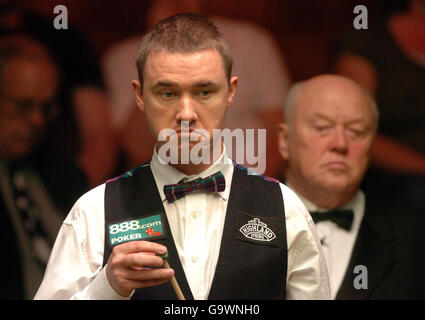 Stephen Hendry, en Écosse, semble mécontent de la table, tandis que Pete Williamson, l'arbitre, regarde pendant le deuxième match des championnats du monde de snooker au Crucible Theatre, à Sheffield. Banque D'Images