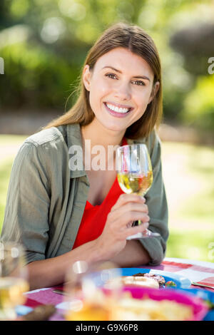 Portrait de femme tenant un verre de vin et souriant Banque D'Images