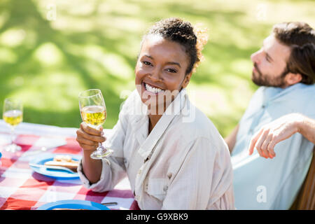 Femme tenant un verre de vin et souriant Banque D'Images