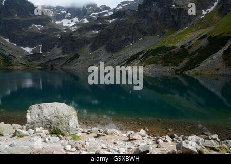 Des pierres sur l'étang noir (Czarny Staw dans Gasienicowy) à proximité des Tatras Zakopane en Pologne Banque D'Images