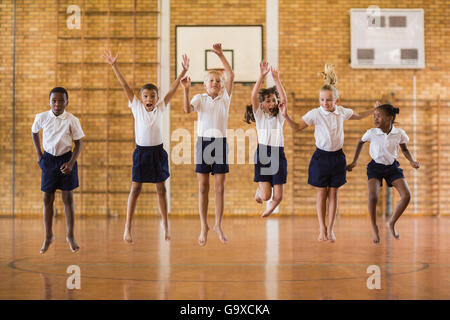 Groupe d'étudiants de sauter à l'école de sport Banque D'Images