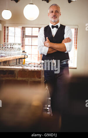 Portrait de barman standing with arms crossed Banque D'Images