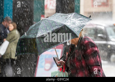Manchester, UK. 1er juillet 2016. Météo France : de fortes averses de pluie torrentielles shoppers tremper dans le centre-ville de Manchester. Le temps incertain dans le nord-ouest de l'Angleterre, pris par surprise les acheteurs avec de lourdes explosions de pluie cet après-midi. Certains ont été préparés, mais d'autres utilisent des techniques alternatives à l'abri. Credit : Cernan Elias/Alamy Live News Banque D'Images