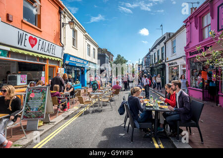 Les visiteurs de Sydney Street jouissant d'un bel après-midi d'été à Brighton, East Sussex. Banque D'Images