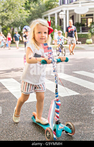 Une jeune fille vêtue de couleurs patriotiques rides son triporteur dans l'indépendance de la communauté sur le défilé du 4 juillet 2016, à Mount Pleasant, Caroline du Sud. Banque D'Images