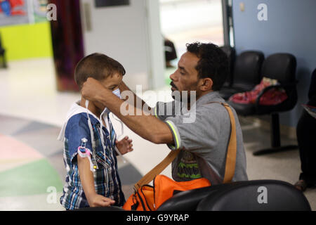 (160705) -- LE CAIRE, 5 juillet 2016 (Xinhua) -- un père lui met un masque pour son enfant à l'hôpital Children's Cancer 57357 L'Egypte au Caire, en Égypte, le 3 juillet 2016. Au coeur de la capitale de l'Egypte Le Caire, des milliers d'enfants atteints de cancer reçoivent un traitement gratuit à la Children's Cancer Hospital Egypte 57357, le plus grand hôpital du cancer de l'enfant dans le monde. Children's Cancer Hospital Egypte 57357, avec 13 unités, est considéré comme un paradis pour les enfants atteints de cancer non seulement de l'Égypte, mais aussi du Moyen-Orient et d'Afrique. L'hôpital a été construit en 2007 et est entièrement dépendant sur les dons des Egyp Banque D'Images