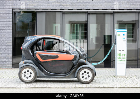 Voiture électrique, Renault, être rechargés au plug-in en face de l'immeuble de bureaux modernes. Banque D'Images