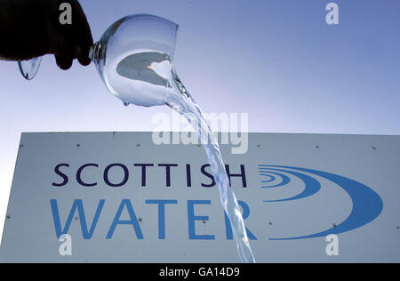 Logo Scottish Water représenté à travers un verre d'eau à Le traitement de l'eau de Carron Valley fonctionne Banque D'Images