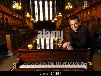 Le concierge et le pianiste virtuose Aleksander Kudajcyk avec un piano à la chapelle de l'Université de Glasgow. Banque D'Images