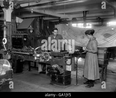 Une machine qui peut produire moins de fumée.Une fille au travail avec une machine ordinaire de fabrication de cigarettes qui produit 7,000,000 cigarettes par mois ou 650 par minute à Messrs Carreras Arcadia Works sur la route de la ville à Londres. Banque D'Images