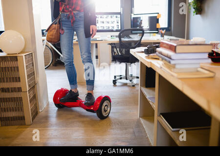 Designer graphique debout sur hover board Banque D'Images