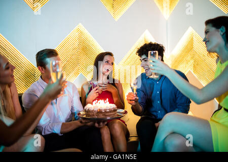 Group of friends toasting un verre de champagne tout en célébrant l'anniversaire Banque D'Images