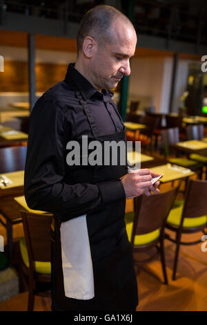 Waiter writing l'ordre sur le bloc-notes Banque D'Images