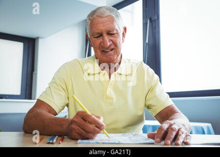 Man en utilisant un livre de coloriage Banque D'Images