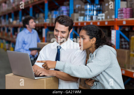 Smiling workers pointing at laptop Banque D'Images