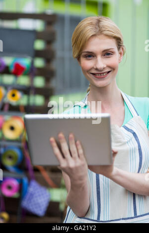 Happy female florist using digital tablet Banque D'Images