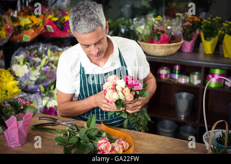 Male florist holding bunch of roses Banque D'Images