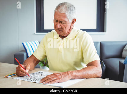 Man en utilisant un livre de coloriage Banque D'Images