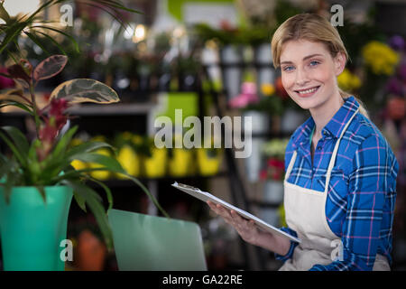 Female florist holding clipboard Banque D'Images